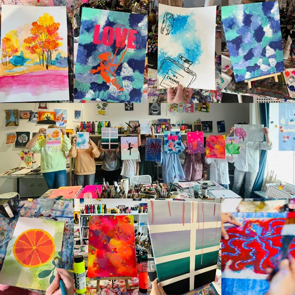 Neun Teilnehmer eines Geburtstags-Workshops in Ilkas Malschule stehen nebeneinander im Atelierraum und zeigen stolz ihre schönen Kunstwerke.
