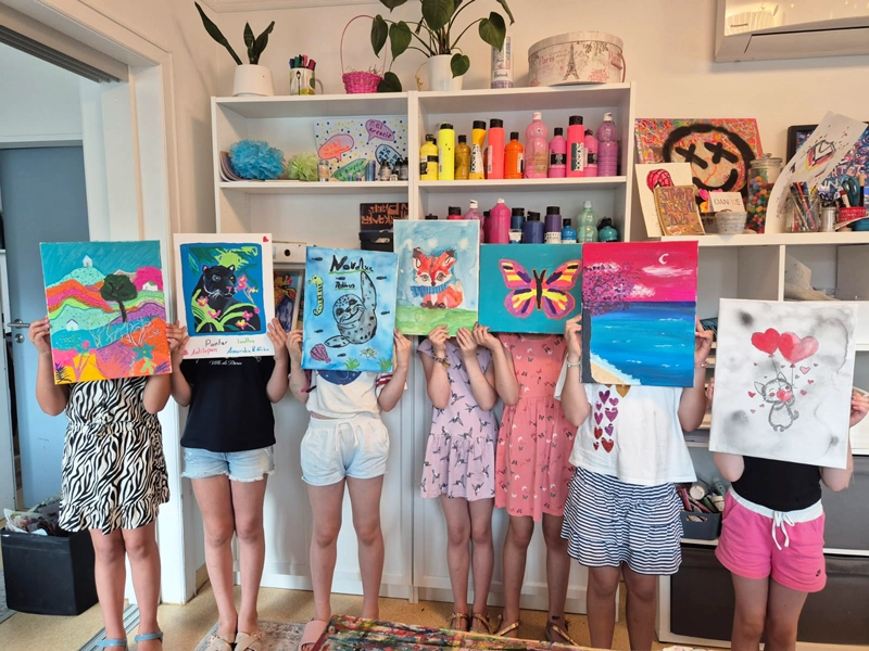 Sieben Teilnehmer eines Kindergeburtstages zeigen stolz ihre Kunstwerke.